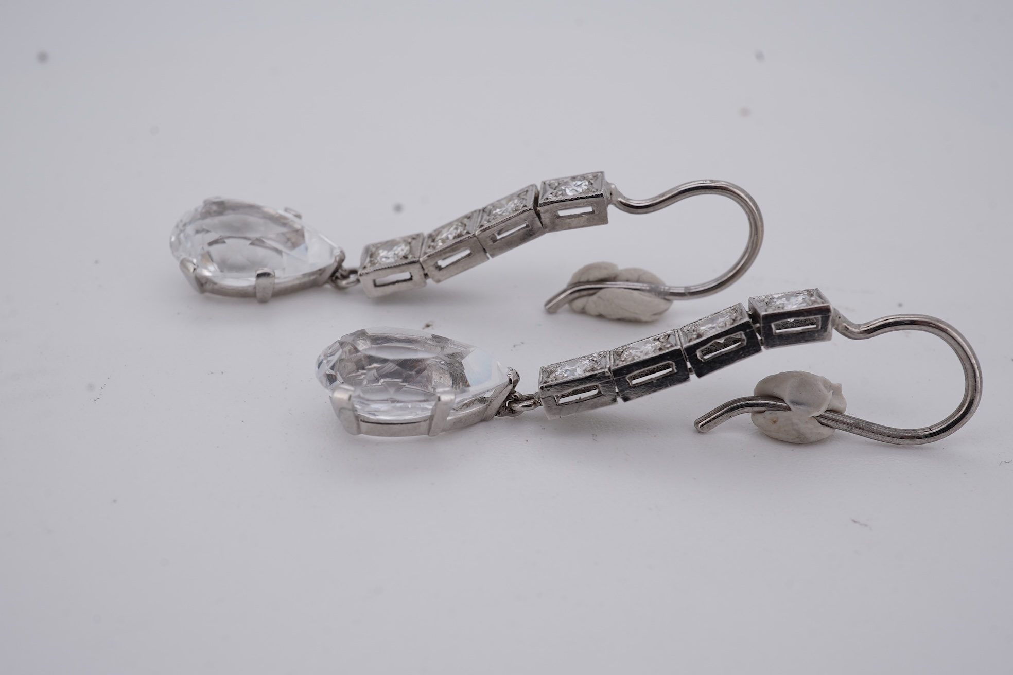 A pair of white metal and four stone diamond set earrings, each with a cubic zirconia pear shaped drop, overall 42mm.